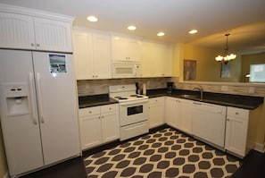 The fully equipped kitchen with granite counter tops, plates, silverware, etc.