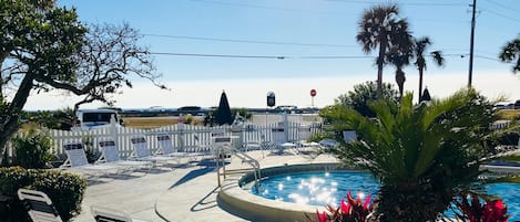 View of the heated pool and lounge chairs from the porch.