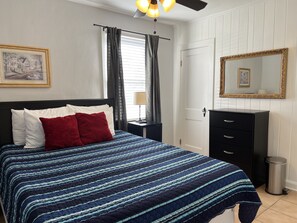 Queen bed with dressers and TV. 