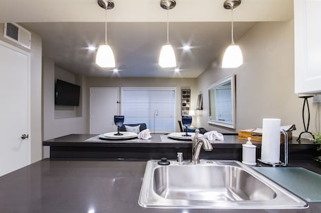 View of TV from Kitchen. Dimmable pendant lights over bar.