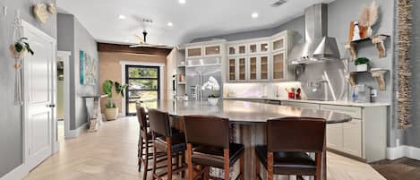 Large, open kitchen with huge island, quartz and quartzite counters.