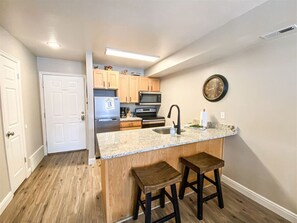 Modern kitchen with granite countertops and cozy seating—perfect for coffee, cooking, and conversation.