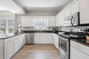 Kitchen - The fully stocked kitchen features both small and large appliances, which include a dishwasher, smoothtop cooktop and oven, built in microwave, and refrigerator with ice maker.