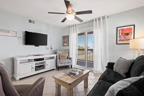 Living Area - The spacious living area features a sofa sleeper, mounted television and balcony access.