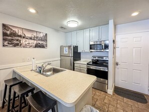 Modern kitchen with bar seating and stainless steel appliances—perfect for cooking and conversation.