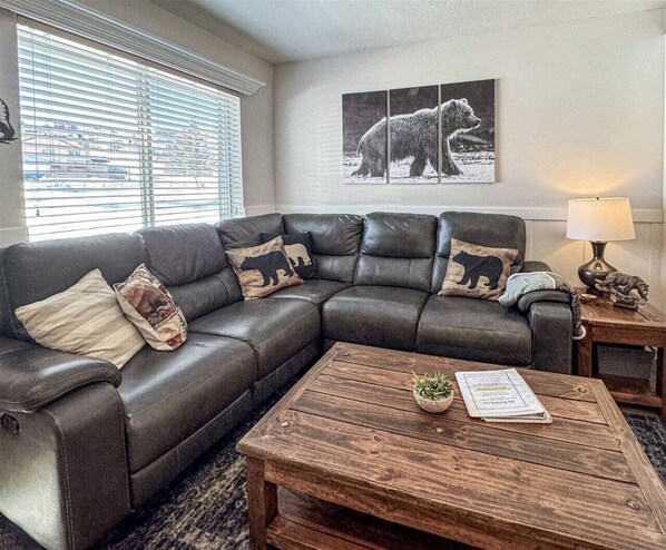 Cozy up on the plush sectional with rustic bear décor and natural light-filled charm.