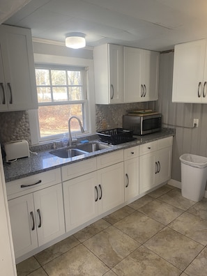 Granite Countertop Kitchen with Microwave, stove, & fridge