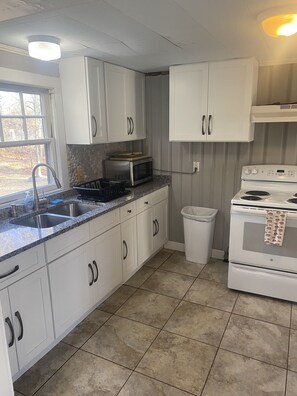 Granite Countertop Kitchen with Microwave, stove, & fridge