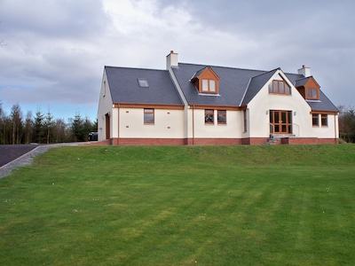 Familienhaus, umgeben von Rasen und Wäldern mit Blick auf die Landschaft