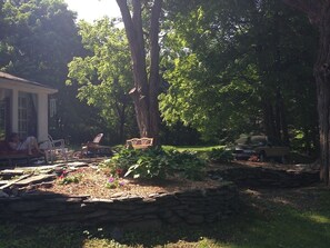 Stone Patio view from  front lawn with canopy of trees and gardens