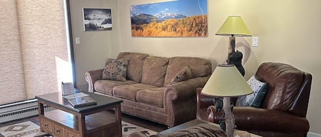 Living room with 65 in TV, two recliners, sleeper sofa and access to the patio.