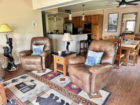 Living room with 65 in TV, two recliners, sleeper sofa and access to the patio.