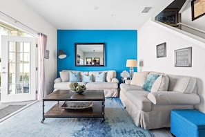 View of the living room facing the back area of the house  and the dining area