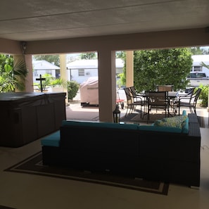 1st floor with grill, dining table, sitting area, hot tub and TV