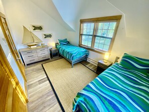 Guest bedroom with two twin beds, dresser, large closet and lots of windows!