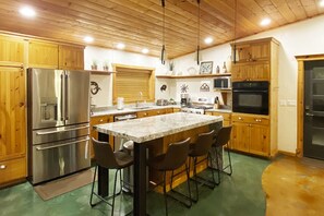 Open kitchen w/ center island, gourmet gas stove, 3 ovens, water/ice dispenser