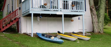 View of the cottage from the lake with kayaks.