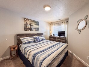 Cozy coastal-themed bedroom with warm lighting—perfect for a restful retreat by the lake.