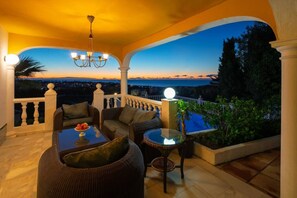 Covered terrace with cozy seating, ideal for sea views and serene sunrises.
