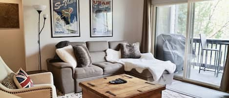 Cozy living room area with deck and view into the woods