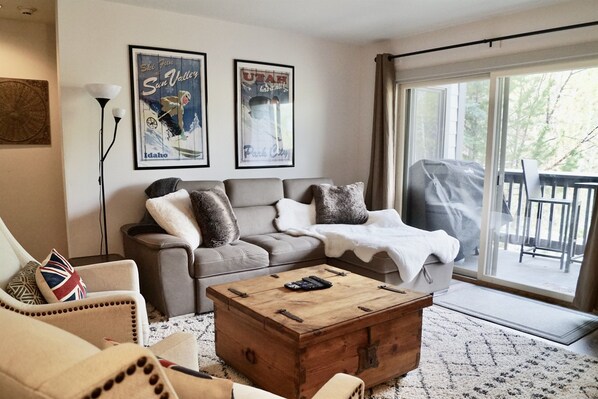 Cozy living room area with deck and view into the woods