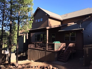 Covered deck with table and BBQ grill.