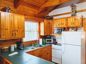 The kitchen with stove, microwave, full-size fridge and full kitchen amenities. 