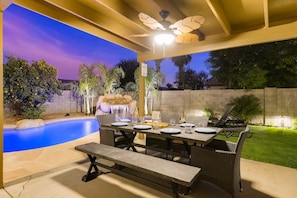 Chat and enjoy your dinner at this outdoor dining table surrounded by friends. 