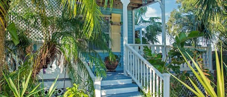 Steps and entrance to porch leading up to doorway to apartment. 