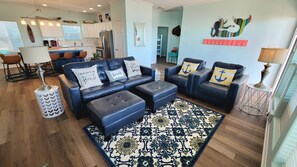 With nearly 50” of entertainment, wall-to-wall windows, and plenty of cozy seating, this living area is made for relaxation and fun.