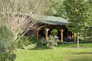 Covered post and beam porch overlooks 1 acre yard.