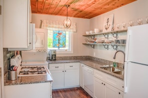 updated kitchen with granite top and gas stove/oven