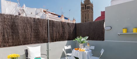 TERRAZA PRIVADA con vistas a la Giralda. Mesa, sillas y butacas