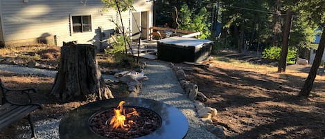 Fire table seating area overlooking deck and spa with lake, mountain view.