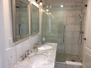 Marble floor and walls extends into large walk-in shower.