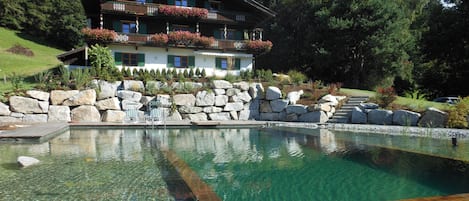 Haus im Sommer mit Naturschwimmteich