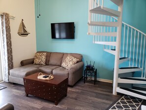 Living area with sprial staircase to Loft