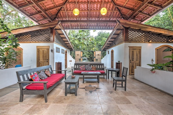 Gorgeous central living room porch surrounded by gardens. Artisan wood and tile.