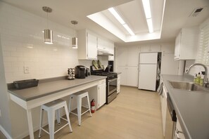 Kitchen is fully loaded with ample counter space. Some food is also stocked.
