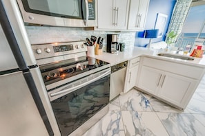 - Fully equipped kitchen with stainless steel appliances, perfect for preparing meals - Modern design with sleek countertops, extra storage & essential cookware provided - Enjoy cooking with ocean views just steps away from this bright & open space
