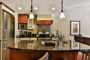 The gourmet, eat-in kitchen is fully stocked and features stainless steel appliances.