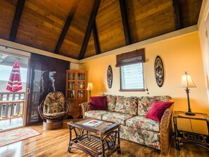 Living room area in the great room with vaulted ceilings and ceiling fan