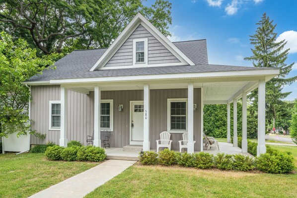 Front of property w/ two sided front porch w/ adirondack chairs and rocker.