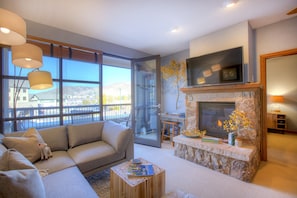 Warm fireplace, large flat screen TV, and balcony with views