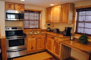 Full stocked kitchen with modern refrigerator and oven.