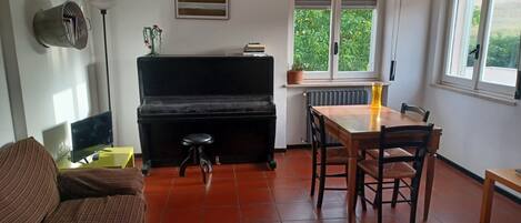 The Living room with TV set a piano, and a view to the Basilicata mountains 