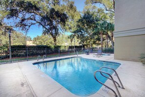 Pool Area with Shaded Seating Under Live Oaks - Framed by palms and centuries-old oaks, the pool offers a quiet spot to swim, lounge, or recharge between beach walks and dinner plans.