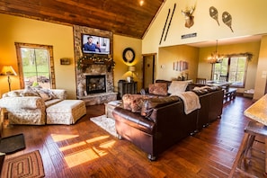 Living room with leather and suede furniture, gas log fireplace and TV