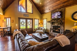 Living room with leather and suede furniture, gas log fireplace and TV