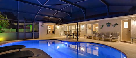 Relax by the illuminated pool under a screened lanai for ultimate privacy and comfort.
